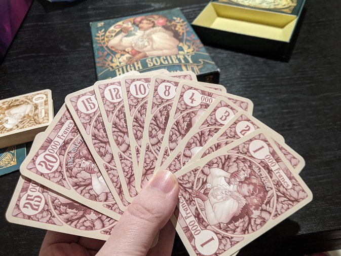 Showing off all of the currency cards in High Society.
