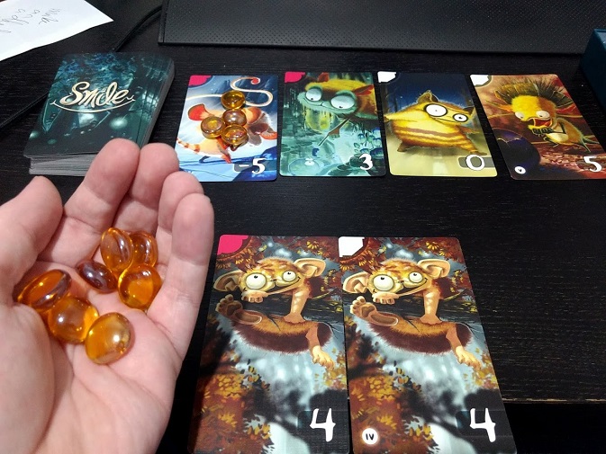 Deliberating whether to spend gems in Smile card game. There's already a lot on a -5 card.