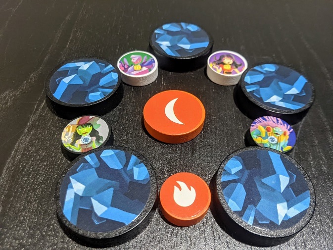 A few of the components organised in a star pattern. Shows off the different character tokens, the fire ball, the wave, and landmarks.