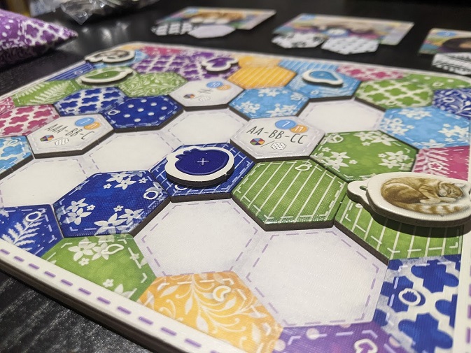 A game of Calico mid way through. Some spaces still remain. Cat token of a sleeping cat.