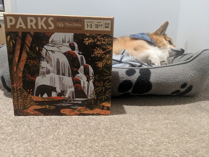 Chester the Corgi lies in bed in the background, Parks game box in the foreground.