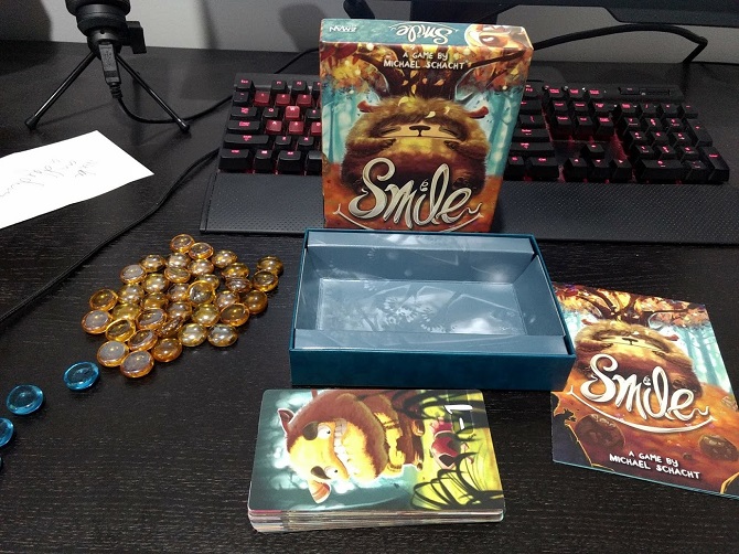 Smile game components, amber and blue beads, and a deck of cards.