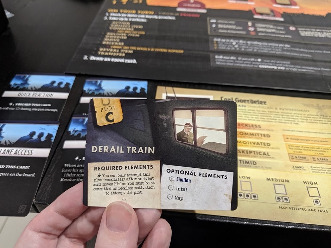 A Black Orchestra plot card: Derail train. Shows Hitler on a train reading a paper.