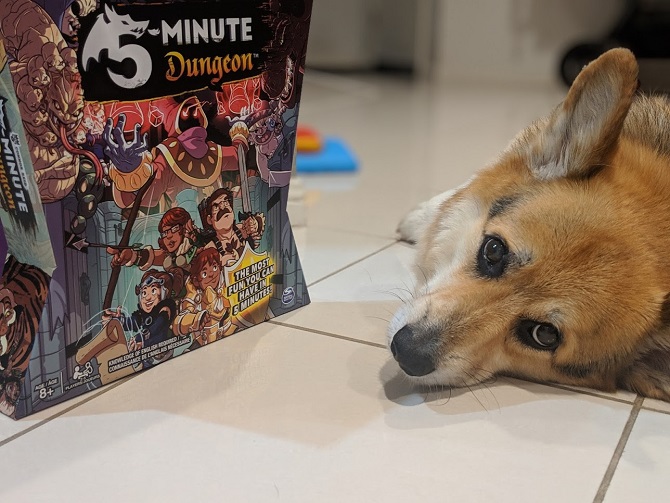 Incredibly cute corgi next to a board game box 5-minute dungeon