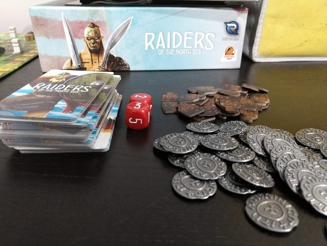 Raiders of the North Sea metal coins, cardboard provision tokens, two red dice, a deck of crew cards.
