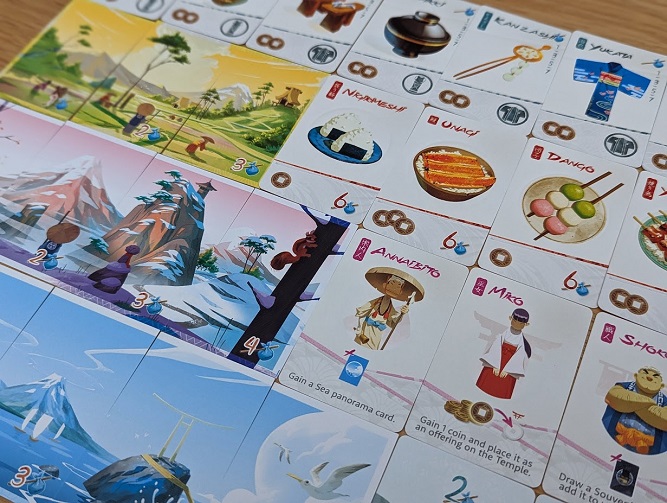 A number of different cards from the game including souvenirs, food, encounters and panorama cards.